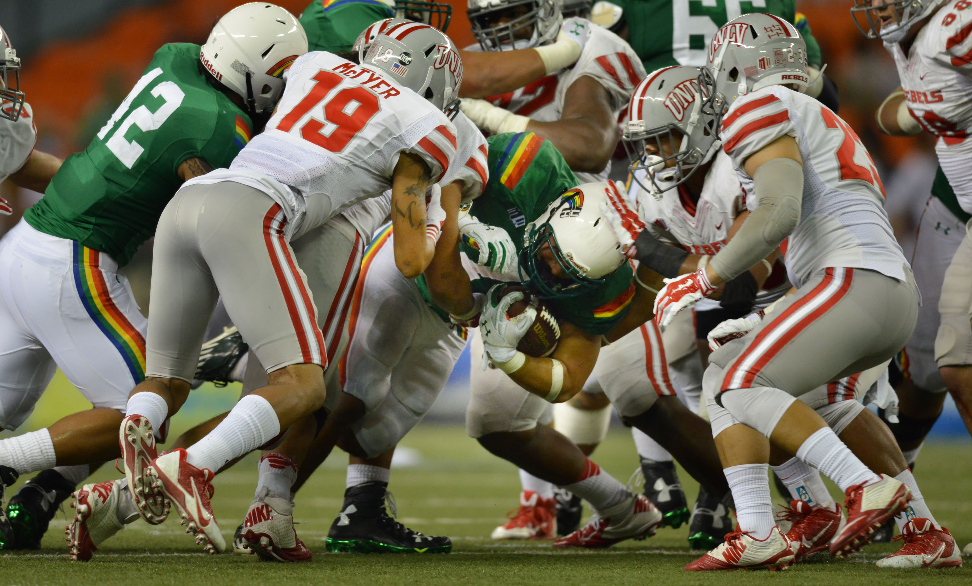 UNLV defensive attempts to stop Hawaii Rainbow Warriors in the first half of action at Aloha Stadium.  ALOHA STADIUM, HONOLULU, HAWAII. photo CORY LUM/ CIVIL BEAT