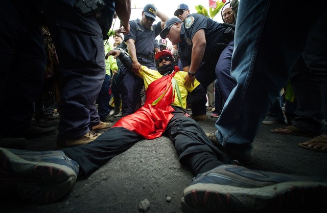 TMT demonstrator lays on the ground refusing to move out of the DLNR motorcades movement up the Maunkea Observatory access road as hundreds of anti TMT and protect Maunakea demonstrators slowed the movement of the DLNR motorcade from the Maunakea Visitors Center. 24 june 2015. photograph Cory Lum/Civil Beat