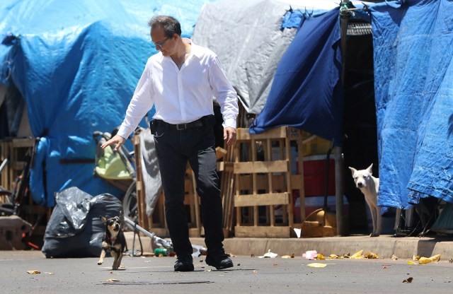Representative Tom Brower walks down Ohe Street as a dogs popped out from tents to bark at him while was on his way to the Olomehani street intersection for press conference. photograph Cory Lum/Civil Beat