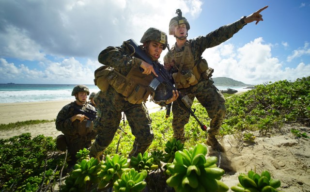 US Marines storm Pyramid Rock Beach Marine Corps Base Hawaii after landing on beach via Amphibious Assault Vehicles in RIMPAC exercises. Kaneohe Hawaii. 30 july 2016