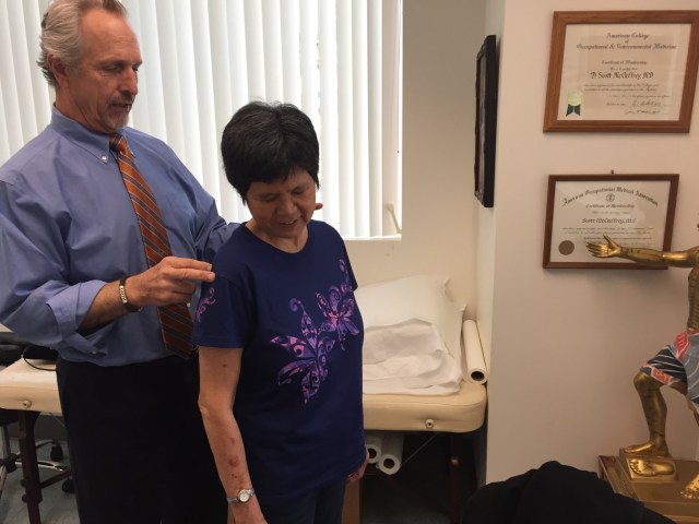 Dr. Scott McCaffrey examines injured worker Bonnie Chan
