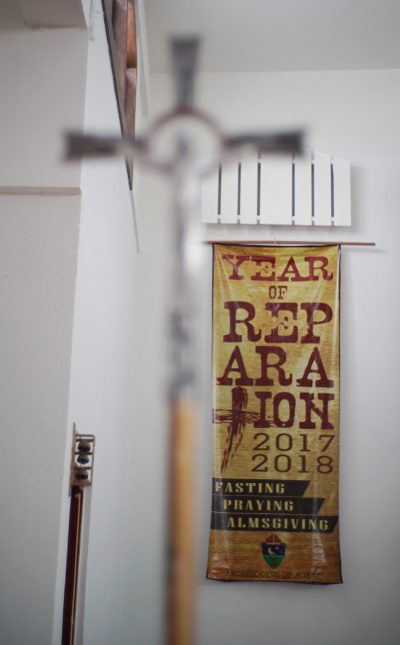 Cross located inside Mount Carmel Church in Hagat, Guam. Church that former Father Anthony Apuron allegely sexually abused Roy Quintanilla and Roland Sandia. Year of Reparation 2017 2017 banner.