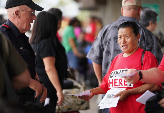 Imaculata Afituk hands out leaflets asking the public for support for United Airlines food workers to unionize at Daniel Inouye International Airport, United curbside area.