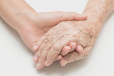 Help concept,Woman holding senior woman's hand on bed, noise and film grain style.
