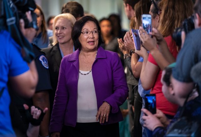Sen. Mazie Hirono, D-Hawaii, with Sen. Kirsten Gillibrand, D-N.Y., left, is applauded by demonstrators as the arrive to speak to reporters in support of professor Christine Blasey Ford, who is accusing Supreme Court nominee Brett Kavanaugh of a decades-old sexual attack, during a news conference on Capitol Hill in Washington, Thursday, Sept. 20, 2018. (AP Photo/J. Scott Applewhite)