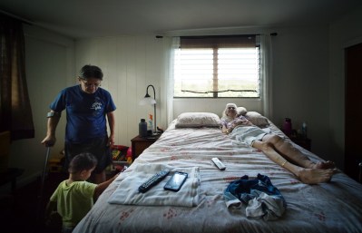 DOE workers comp Ralph Kahoopii with his wife Jo Ann on her bed.