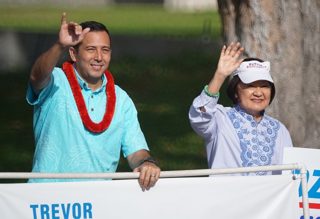 City Council candidate Trevor Ozawa waves with right Ann Kobayashi at Beretania Punchbowl street.