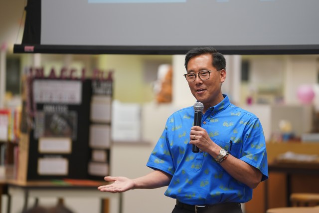 Keith Amemiya, Island Holdings VP speaks and introduces Landed at Farrington High School library.