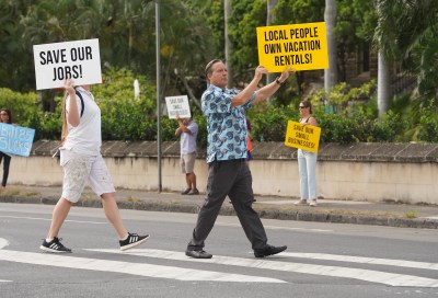 Demonstrators against City Council Bills 89 and 85 cross the street near Honolulu Hale.
