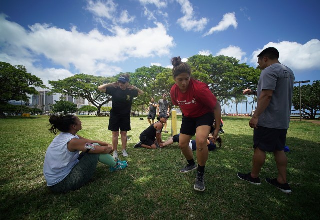 HPD Recruitment Training as left, HPD Officer Ilse Pratt talks about sit ups and how many recruits need to accomplish in a set amount of time at Magic Island.