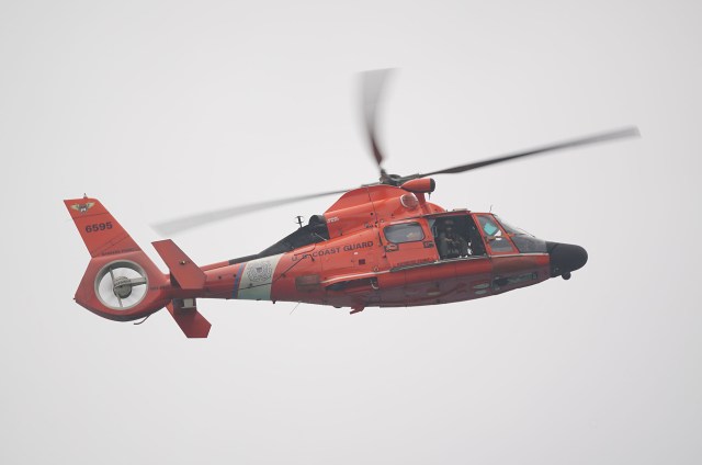 US Coast Guard helicopter cruises past Sandy Beach.