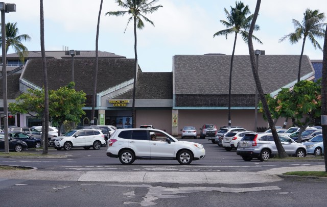 Hawaii Kai Shopping Center showing damaged asphalt and older buildings