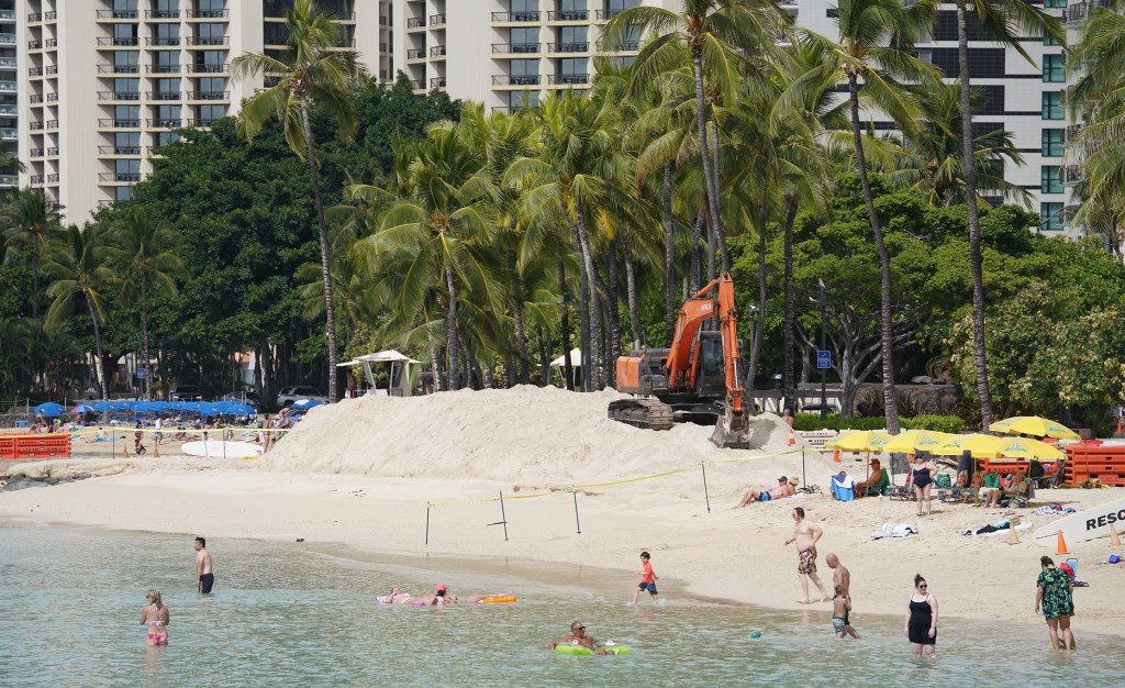 Waikiki Beach Sand replenishment near visitors enjoy the beach. Just before the Kapahulu groin area.