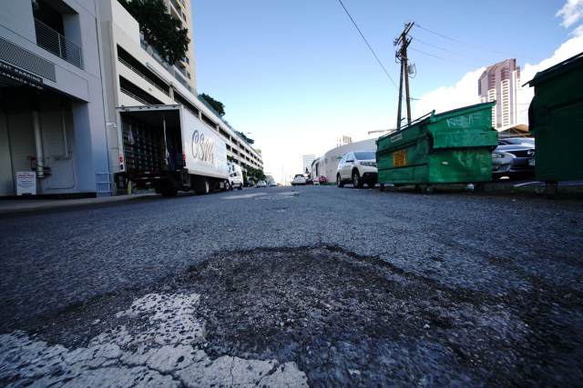 Ilaniwai Street in Kakaako with potholes in foreground.