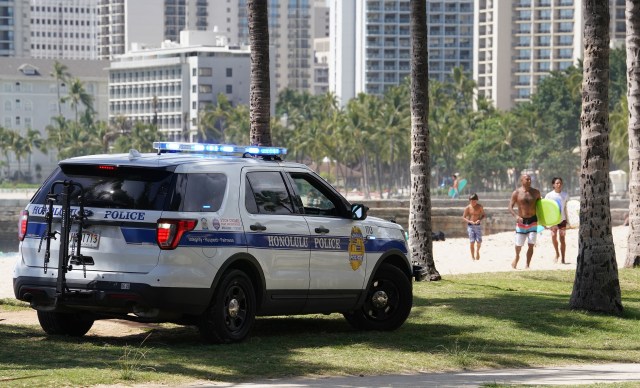 HPD on a loudspeakers tells beachgoers that they cannot be on the beach. Surfing is allowed.