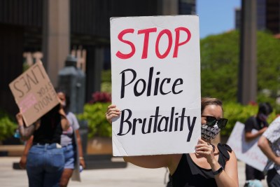 Supporters of George Floyd rally fronting the Capitol with a sign that reads, ‘Stop Police Brutality’.