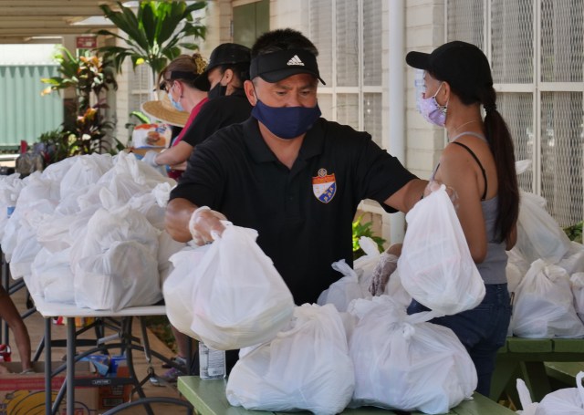 Volunteers from the Lodge Le Progres De L'Oceanie of the Free & Accepted Masons of Hawaii, prepare bags, of free groceries, to be given out to community members in need, at the drive through distribution event they held, at Kaimuki High School on Sunday, May 17, 2020, in Honolulu, HI. (Ronen Zilberman photo Civil Beat)