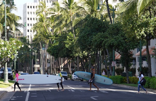 Kalakaua Avenue with no traffic as surfers cross during COVID-19 pandemic. June 1, 2020