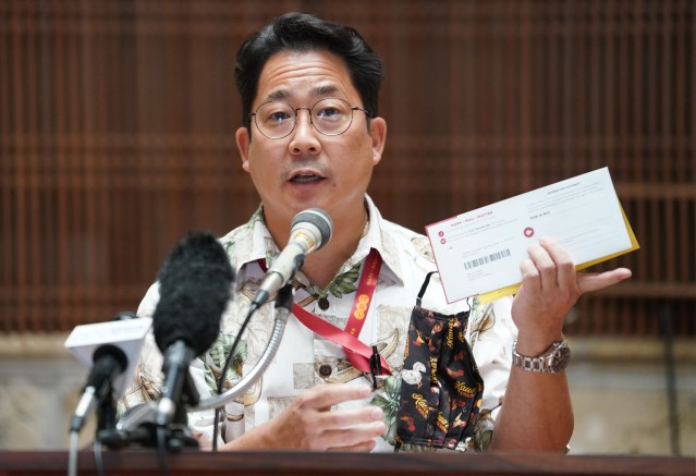Honolulu City Clerk Glen Takahashi holds a ‘mail in ballot’ during press conference held at Honolulu Hale.