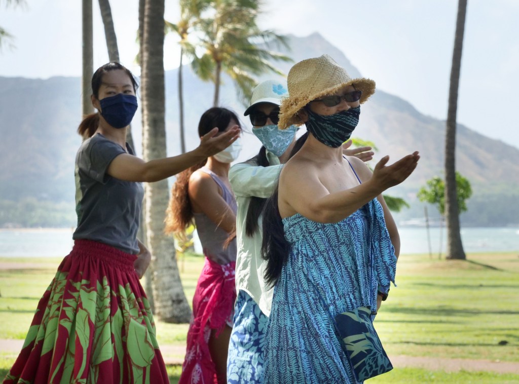 A group of women dance hula together under the direction of Kumu hula Mahealani Kalikolau 'olenakalani at the Magic Island Park in Honolulu, Thursday, July 9, 2020. (Ronen Zilberman photo Civil Beat)