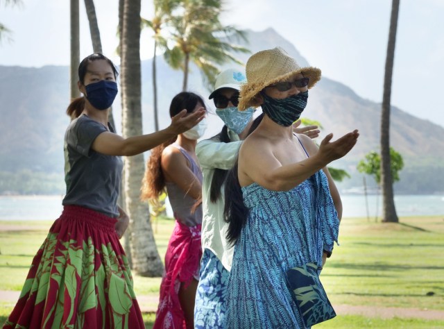 A group of women dance hula together under the direction of Kumu hula Mahealani Kalikolau 'olenakalani at the Magic Island Park in Honolulu, Thursday, July 9, 2020. (Ronen Zilberman photo Civil Beat)