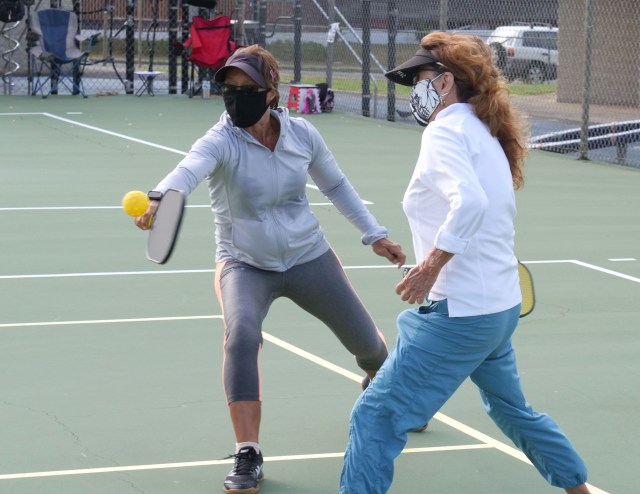 Aina Haina residents enjoy a game of pickleball with protective masks at Waialae Iki Park in Aina Haina, HI, Tuesday, July 15, 2020. Invented in 1965 in Washington State, pickleball can be played on a traditional tennis court with smooth paddles and a plastic hole-filled ball. (Ronen Zilberman photo Civil Beat)