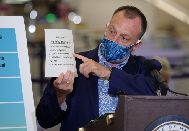 Hawaii Lt. Govenor Josh Green points to a sign as he explains traveler safety guidelines during a media briefing Tuesday, Oct. 7, 2020 in Honolulu, HI. The briefing was held to unveil new COVID-19 safety measures the state plans to implement upon opening to travelers on October 15th. (Ronen Zilberman photo Civil Beat)