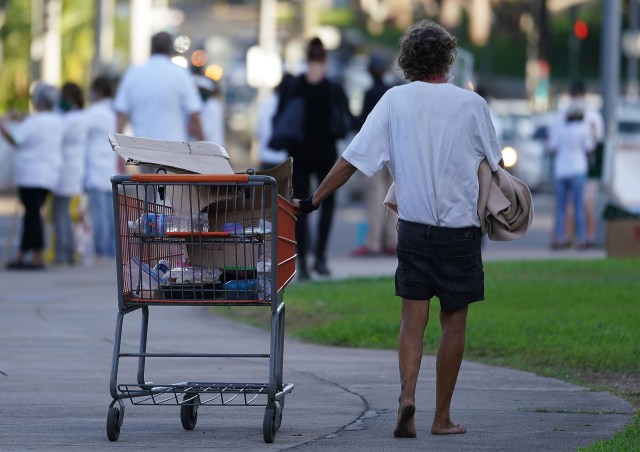 Person pushes their cart with their belongings barefooted fronting the Capitol during COVID-19 pandemic. October 14, 2020
