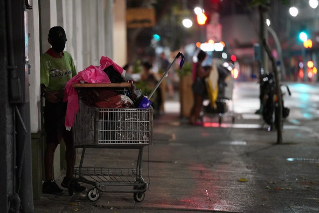Masked person waits with his shopping cart along Hotel Street in Chinatown during COVID-19 pandemic. October 26, 2020