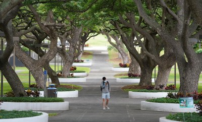 University of Hawaii at Manoa Mall usually is full with students changing classes and walking thru campus on a wednesday at midday. Lone masked student during COVID-19 pandemic. October 21, 2020
