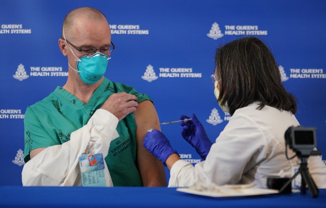 Queen’s Medical Center frontline COVID-19 worker, Dr. Lester Morehead, MD receives part 1 of the Pfizer COVID-19 vaccine given by right, Ruby Takahashi APRN at a press event held at Queen’s Medical Center. December 15, 2020