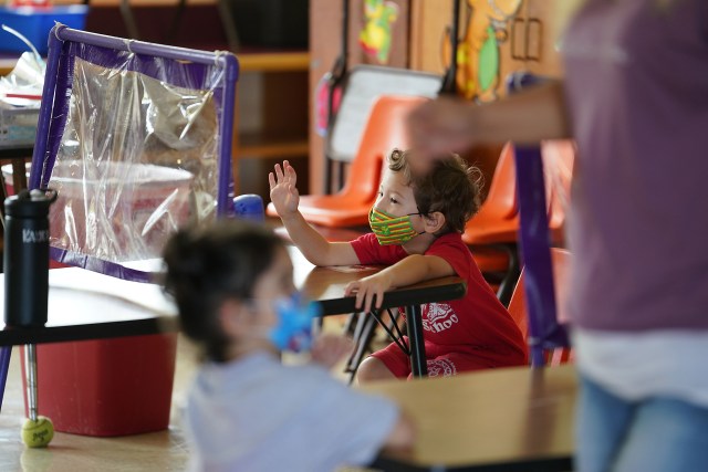 St. Ann School early learning class with students and the plastic barriers as protection during in person class.