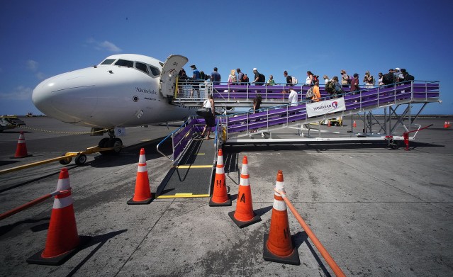 Passengers walk up ramp to board a Hawaiian Airlines flight bound to Honolulu.
