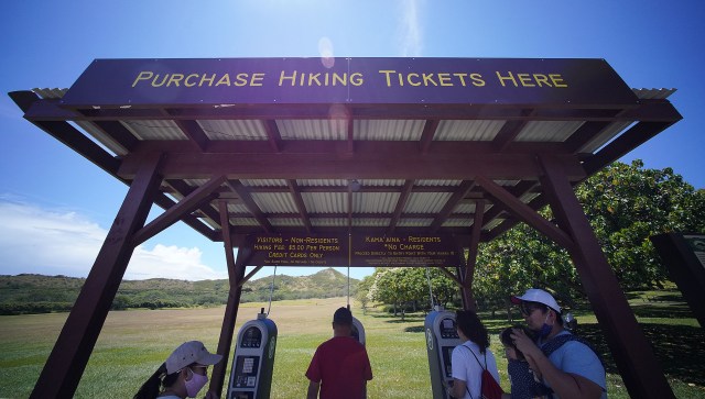 Visitors buy tickets at a kiosk inside the Diamond Head crater before hiking to the summit.