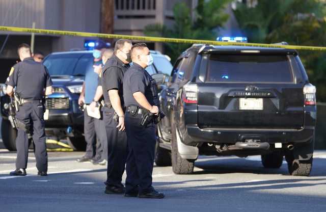 Honolulu Police officers stand at shooting scene at the intersection of Philip Street and Kalakaua Avenue. April 5, 2021