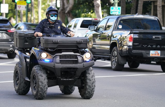 Honolulu Police Department officer rides a all terrain vehicle along Kalakaua Avenue.