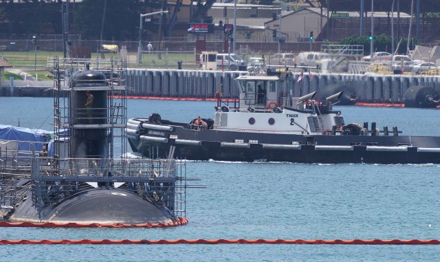 Tugboat Tiger 2 passes near a Navy submarine while docked at Joint Base Pearl Harbor-Hickam.