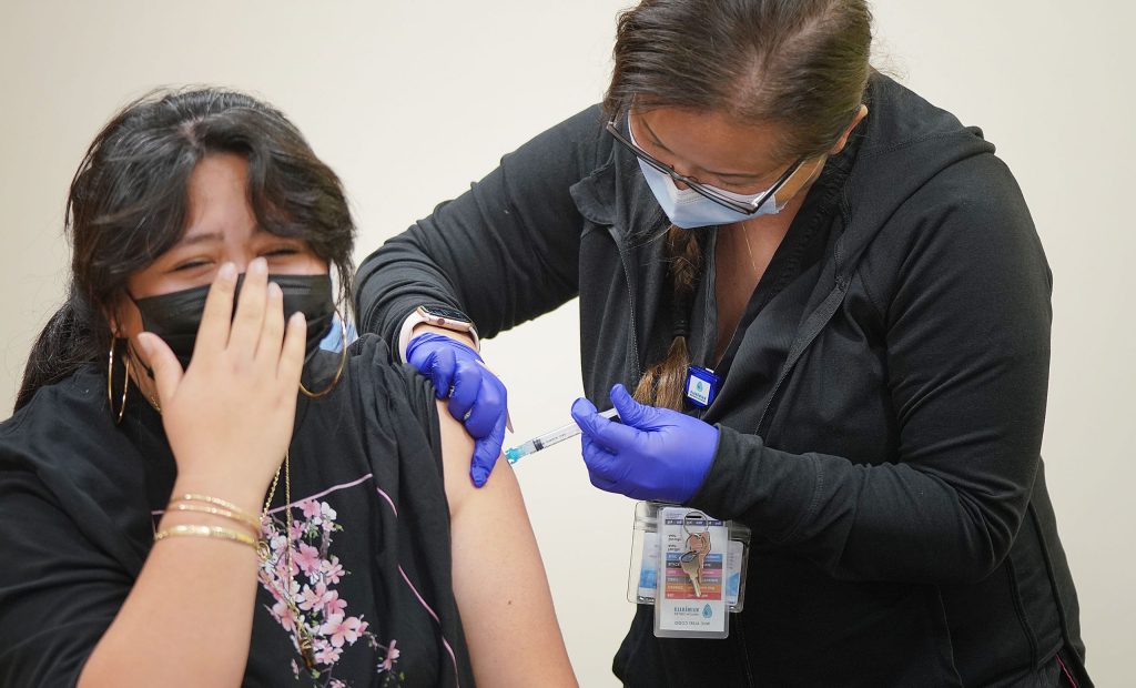 Zinfandel Josiah receives the Moderna COVID-19 vaccine from Registered Nurse Janet Sinclair at the Waimanalo Health Center.