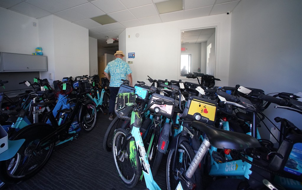 Biki Executive Director Todd Boulanger walks into the entrance of Biki offices in Kakaako filled with damaged bikes.