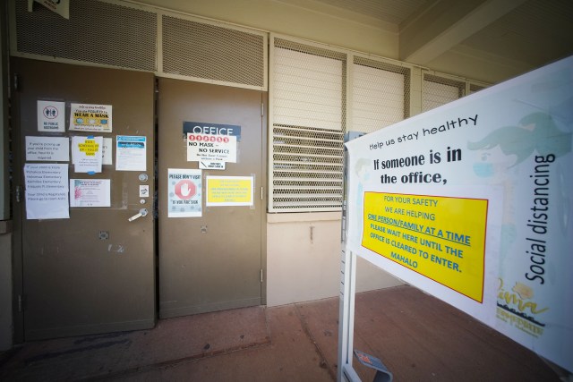 Front entrance to the office administration building at Ilima Intermediate School with COVID-19 warning precautions. July 27, 2021