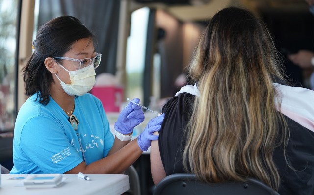 Left, Crystal Alfonso RN moments before vaccinating a student at Ilima Intermediate School.