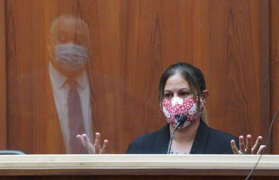 Honolulu police officer Chanel Price listens to questions from defense attorney Richard Sing, reflected in the plexiglass barrier, in the district courtroom of judge William M. Domingo during the third day of preliminary hearings for three Honolulu police officers in the killing of Iremamber Sykap. POOL PHOTO/Cory Lum/Honolulu Civil Beat