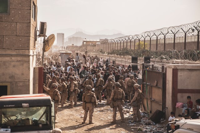 U.S. Marines with Special Purpose Marine Air-Ground Task Force - Crisis Response - Central Command, provide assistance at an Evacuation Control Checkpoint (ECC) during an evacuation at Hamid Karzai International Airport, Kabul, Afghanistan, Aug. 21. U.S. service members are assisting the Department of State with a non-combatant evacuation operation (NEO) in Afghanistan. (U.S. Marine Corps photo by Staff Sgt. Victor Mancilla)