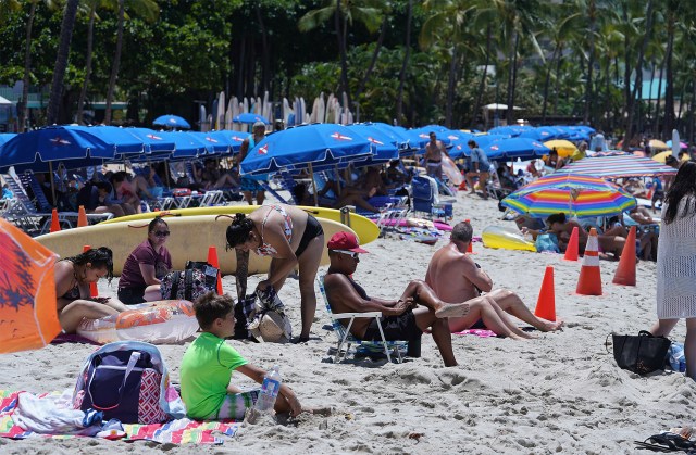 Waikiki Beach packed with people sitting on the sand