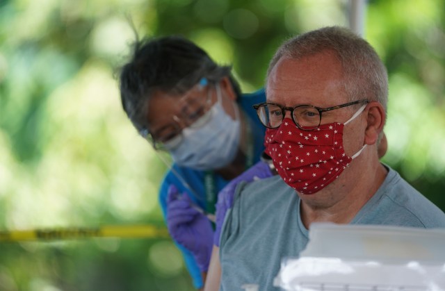 Windward resident George Nardin receives his booster shot from Suzy Shimabukuro, RN under a tent in the back of the Windward YMCA. August 24, 2021.