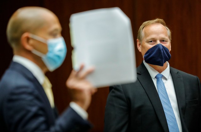 Prosecuting attorney Christopher Van Marter, right, looks on as defense attorney Thomas Otake raises documents in the district courtroom of Judge William M. Domingo during preliminary hearings for three Honolulu police officers in the killing of Iremamber Sykap on Tuesday, Aug. 17, 2021, in Honolulu. (POOL PHOTO/Jamm Aquino/Honolulu Star-Advertiser).