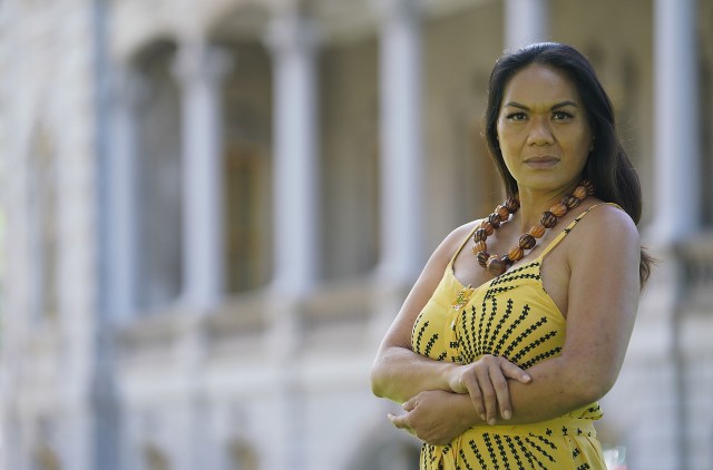 Portrait of Starr Kalihiki with Iolani Palace in the background.