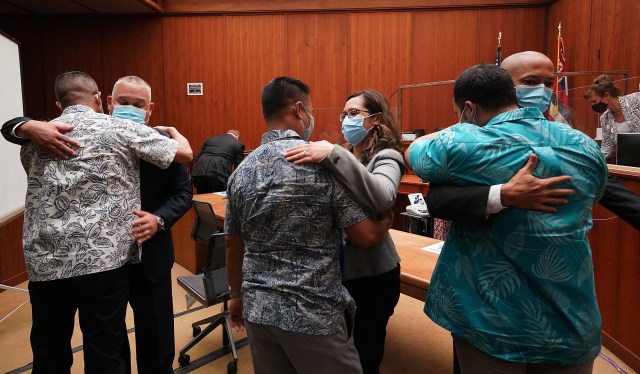 Left to right, defense attorneys Richard H.S Sing embraces his client Geoffrey Thom, center facing camera attorney Crystal K. Glendon embraces her client Christopher Fredeluces and right, facing camera Thomas Otake embraces his client Zackary Ah Nee after Judge William M. Domingo found there was no probably cause in any charges in the fatal shooting of Iremamber Sykap. August 18, 2021.