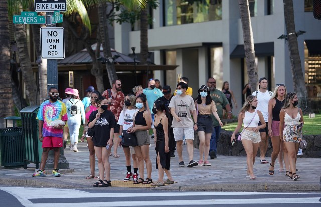 People wait at the intersection of Kalakaua Avenue and Lewers Street during a recent surge in Covid-19 cases. August 22, 2021
