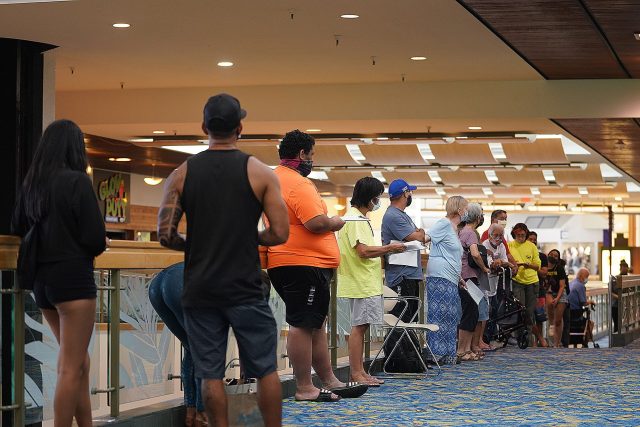 People wait in line outside a Covid-19 vaccination site located at Windward Mall on August 24, 2021.